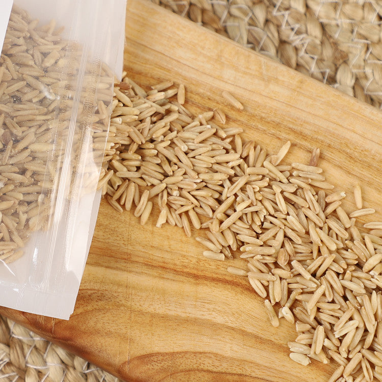 Pesticide-free Korean oats, loose grains in a wooden tray beside a clear bag