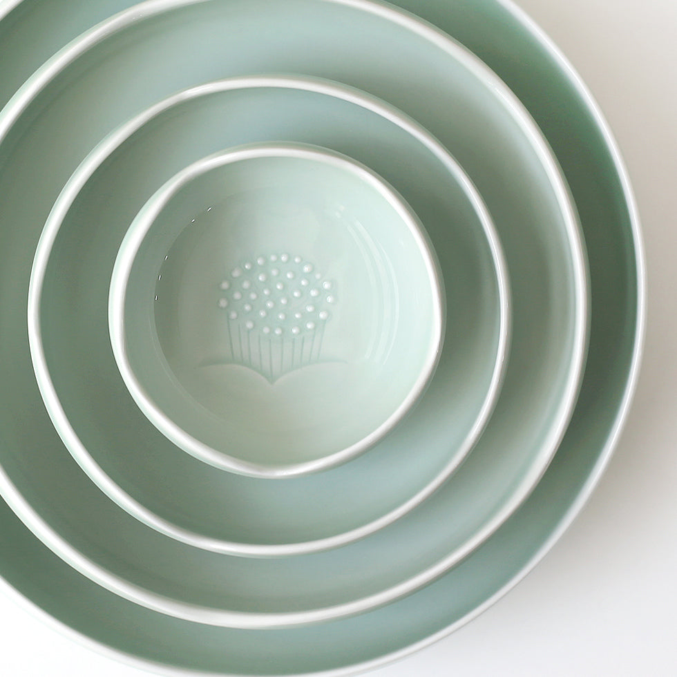 Nested celadon sauce bowls, glossy interior with embossed floral dot pattern