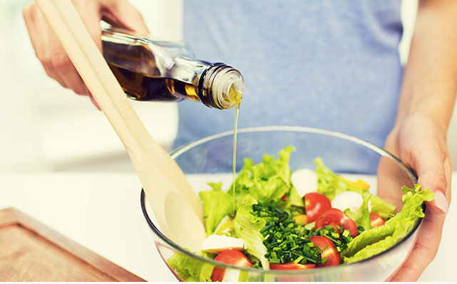 Yuja soy sauce bottle pouring over salad bowl