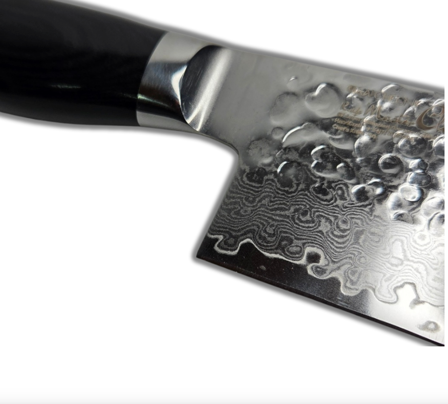 Damascus chef knife close-up with black handle and hammered blade pattern