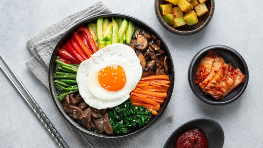 Bibimbap Korean rice bowl with vegetables, egg and gochujang on a modern table setting