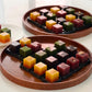 Cube yanggaeng assortments in round wooden tray, colorful red, yellow, green, dark cubes