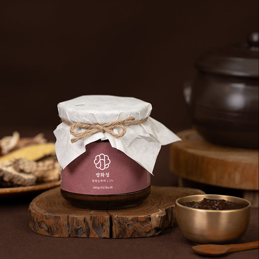 Herbal jar with maroon label, white cloth-tied lid and twine
