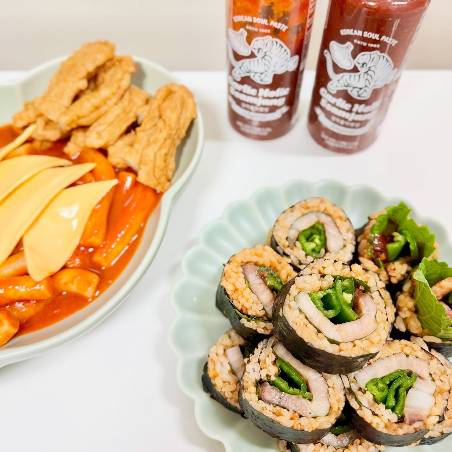 Garlic Holic Ssamjang sauce bottles with kimbap rolls and vegetable side plates