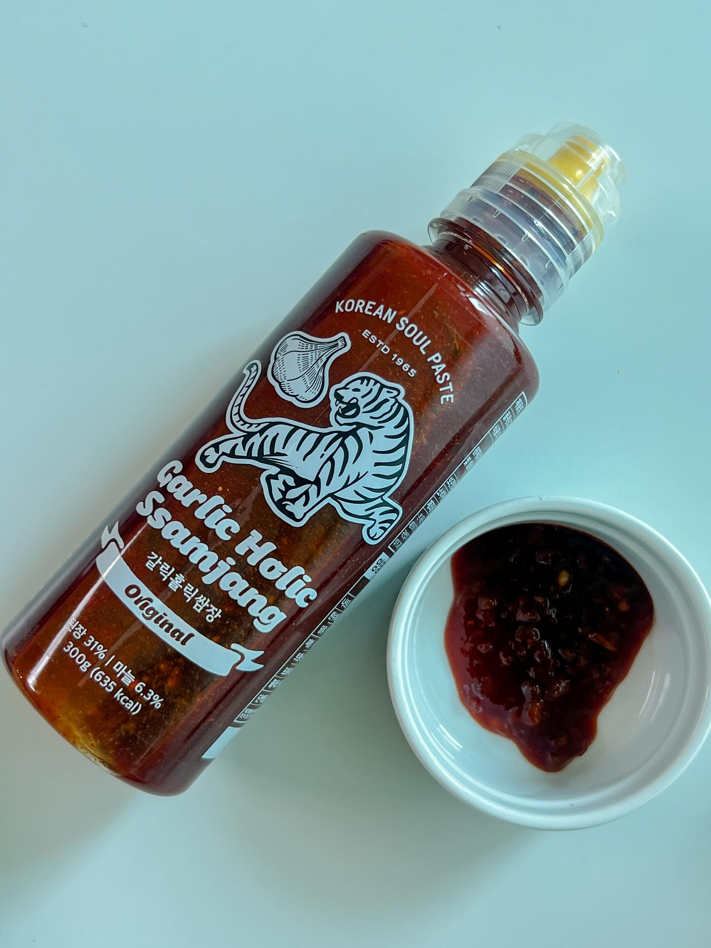 Garlic Holic Ssamjang sauce bottle (Original) with a small cup of dark sauce