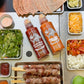 Garlic Holic Ssamjang sauce bottles with grilled skewers and veggie side trays