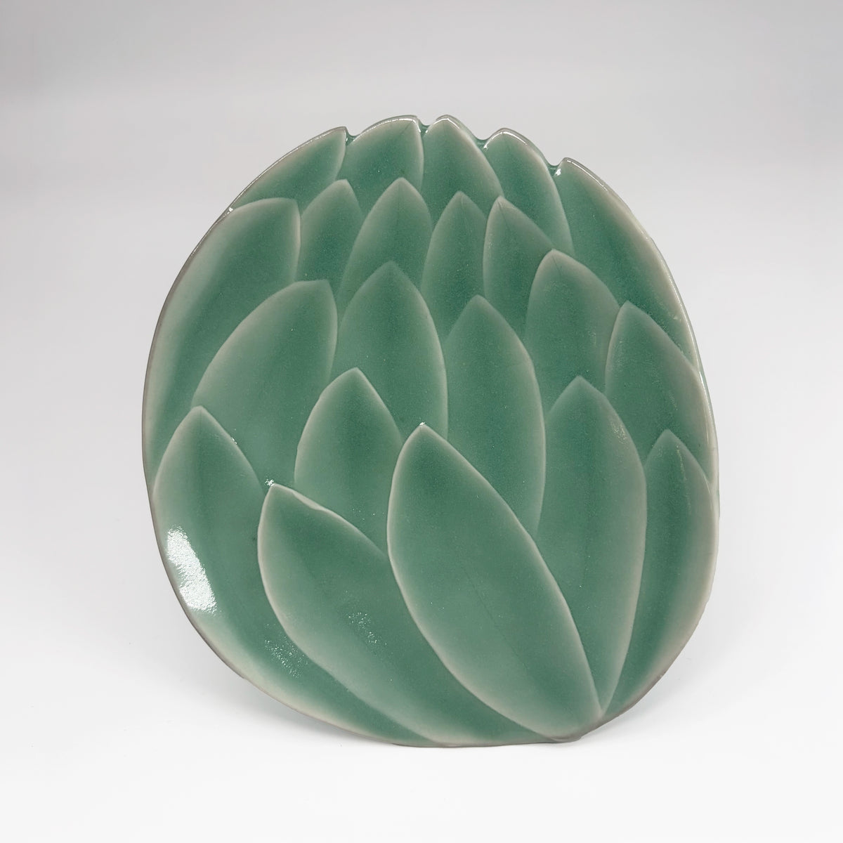 Celadon green lotus dessert plate with raised leaf-petal texture on a shallow bowl