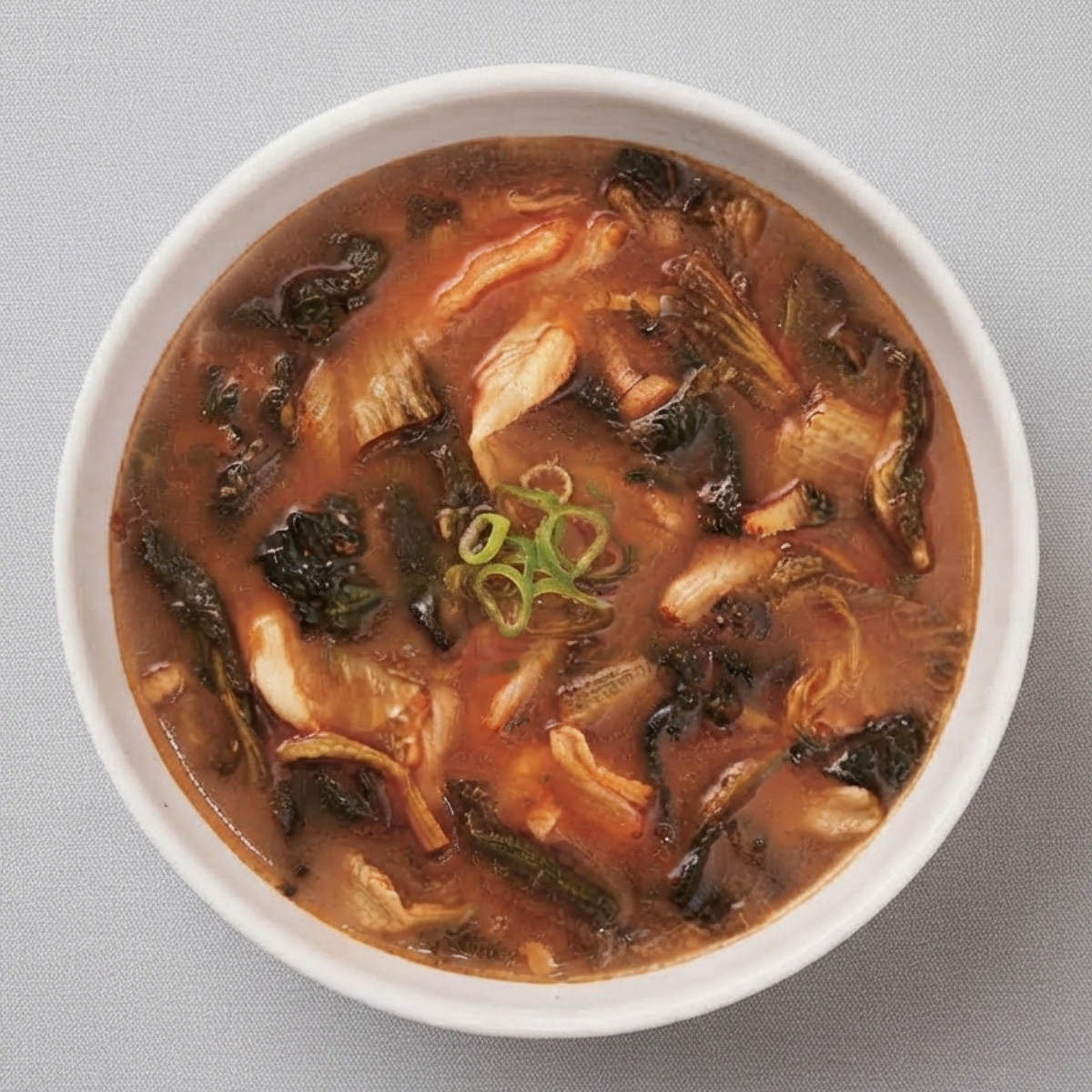 Bowl of instant haejang soup with cabbage, mushrooms, and scallion garnish