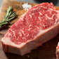 Raw red steak cut on wooden board with rosemary sprigs and pepper