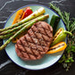 Seared ribeye steak plate with asparagus, potatoes, and herb garnish