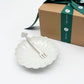 Flower-shaped dessert plate with matching fork resting across it, white ceramic