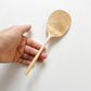 Light wood rice paddle with textured oval scoop held in a hand