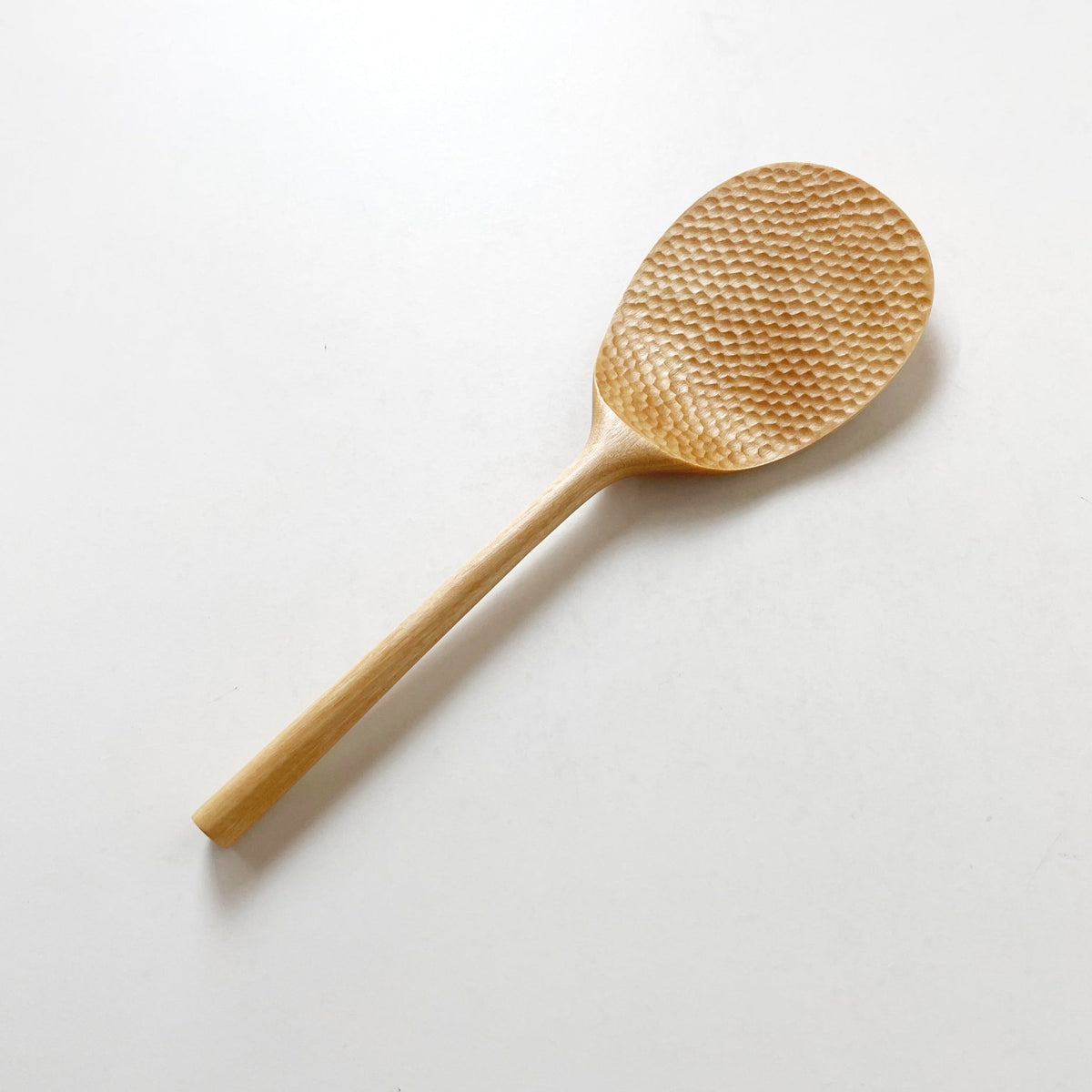Light wood rice paddle with textured oval scoop and long handle, angled