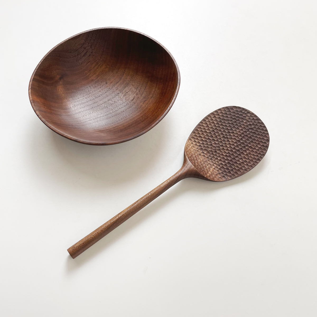 Patterned rice paddle with wooden bowl, dark paddle with textured head and long handle
