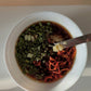 Bowl of chopped dried peppers and herbs with a knife