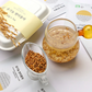 Organic brown rice tea package with brewed tea and brown rice grains in cups