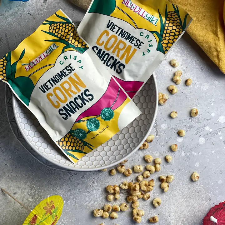 Crispy corn snack bags and plate with scattered golden kernels