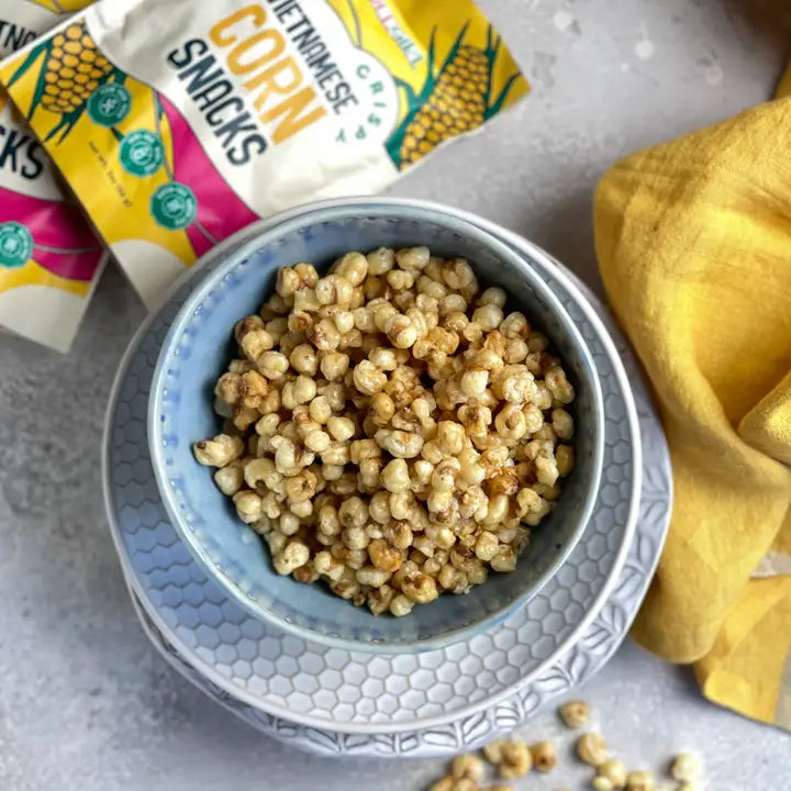 Crispy corn snack in a blue ceramic bowl filled with golden popped kernels