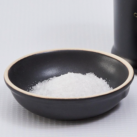 Black bowl of coarse white salt