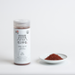 Coarse gochugaru container jar with a small bowl of red chili powder