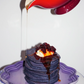 Ube mochi pancake stack with syrup drizzled in purple dish