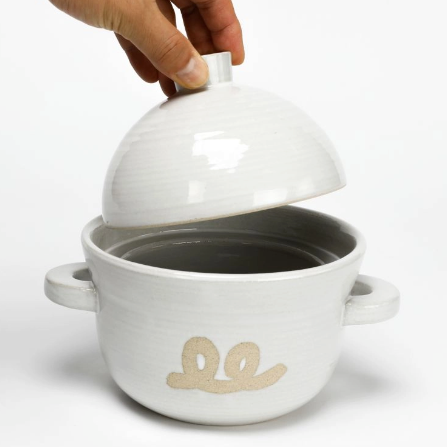 Ceramic rice pot with lid being lifted, white glaze, owl logo, two side handles