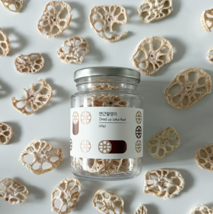 Dried lotus root jar with silver lid surrounded by sliced dried lotus pieces