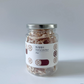 Dried lotus root in glass jar with silver lid, red-brown dried root slices inside