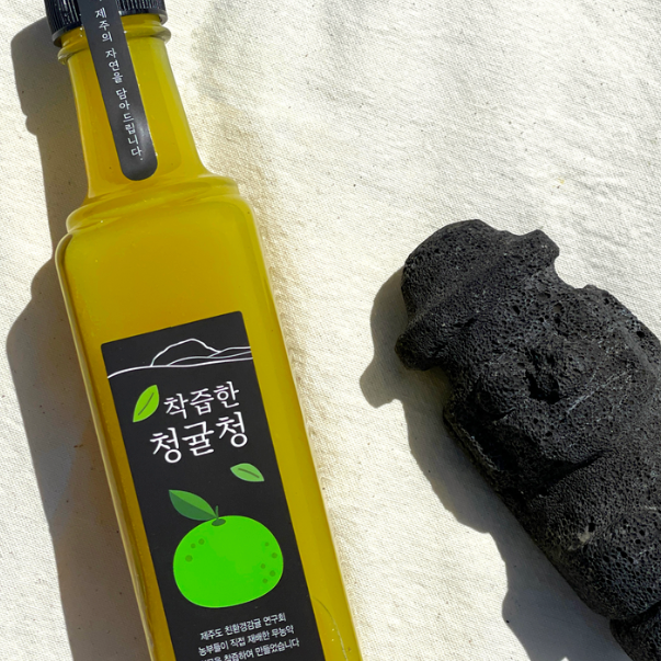 Tangerine extract bottle with yellow liquid and black label, angled view