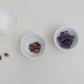 Flower tiny bowl set: three white flower-shaped bowls, one filled with purple dried herbs.