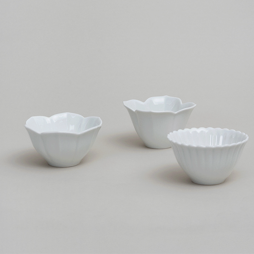 Flower tiny bowl set of three white flower-shaped bowls with scalloped rims.