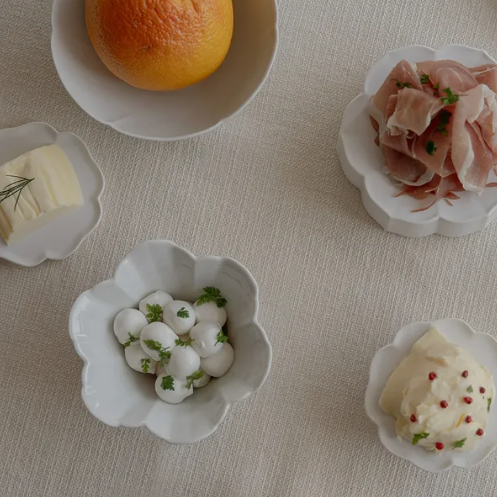Flower tiny bowl set: white flower-shaped bowls holding small bites and garnishes.