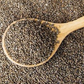 Roasted perilla seeds with spoonful of small dark gray-green seeds