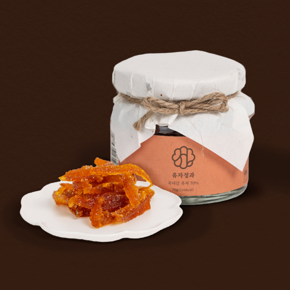 Orange yuja jelly jar with twine tied white lid and plate of candied jelly pieces