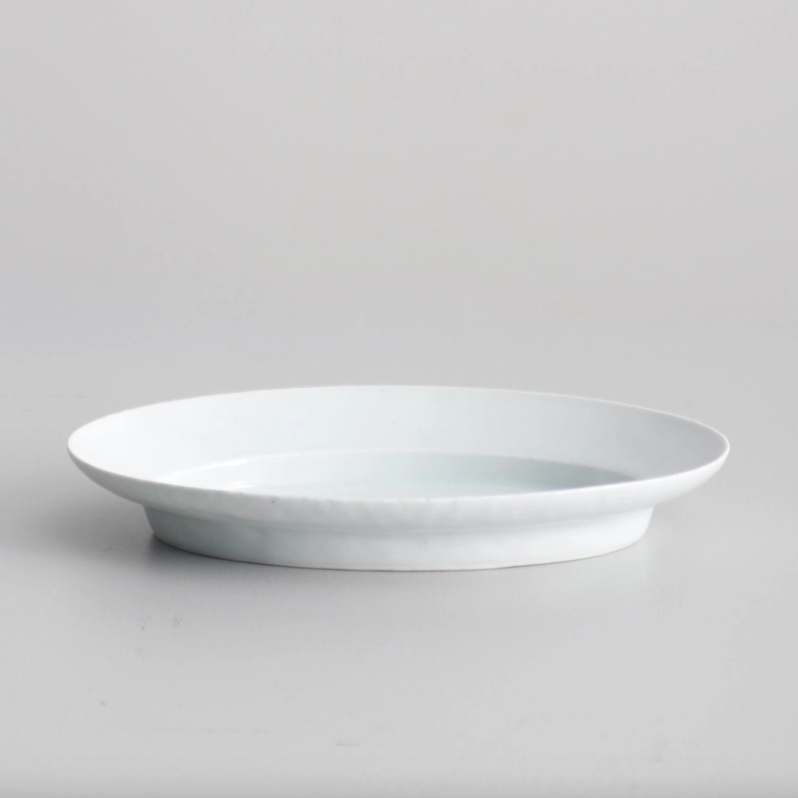 White oval serving plate close-up, shallow bowl with glossy interior