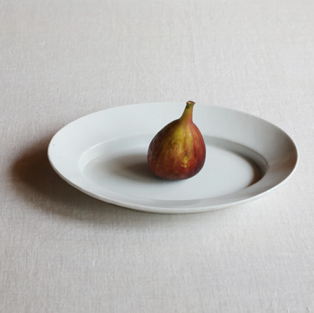 White oval plate with a whole fig on the center