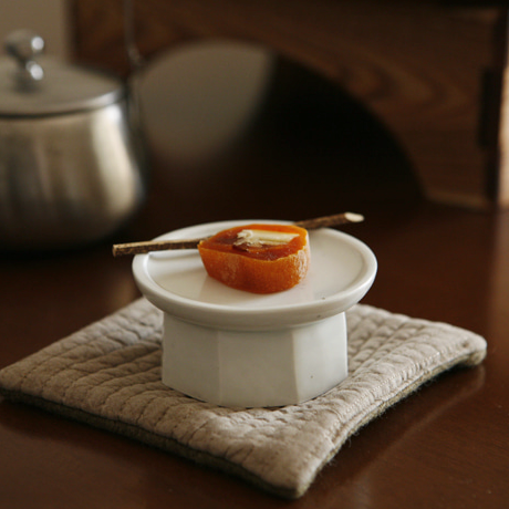 Octagonal petite ceramic soban in light cream, holding an orange snack in the bowl