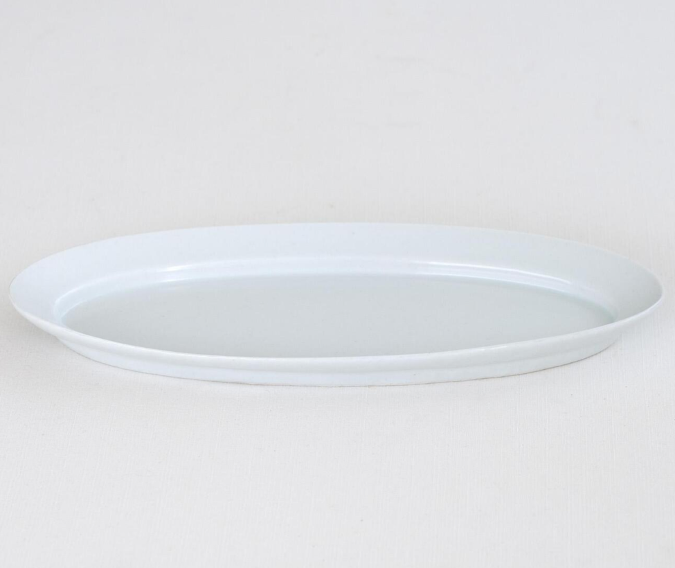White oval serving plate with wide rim and shallow tray