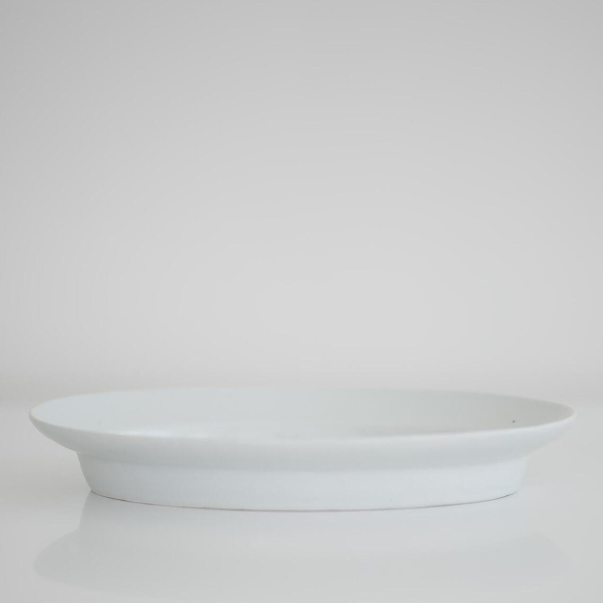 White oval plate, empty, raised rim side view