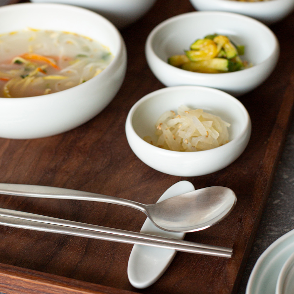 White ceramic one-person bowl set with matching spoon and three serving bowls