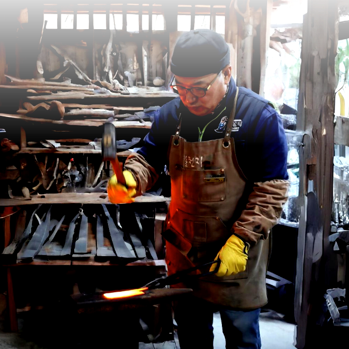 Pairing knife in a workshop, with a craftsman holding the blade
