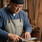 Pairing knife being used by a chef in an apron, stainless blade on board