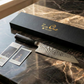 Chef knife gift box with black cover and damascus blade on marble surface