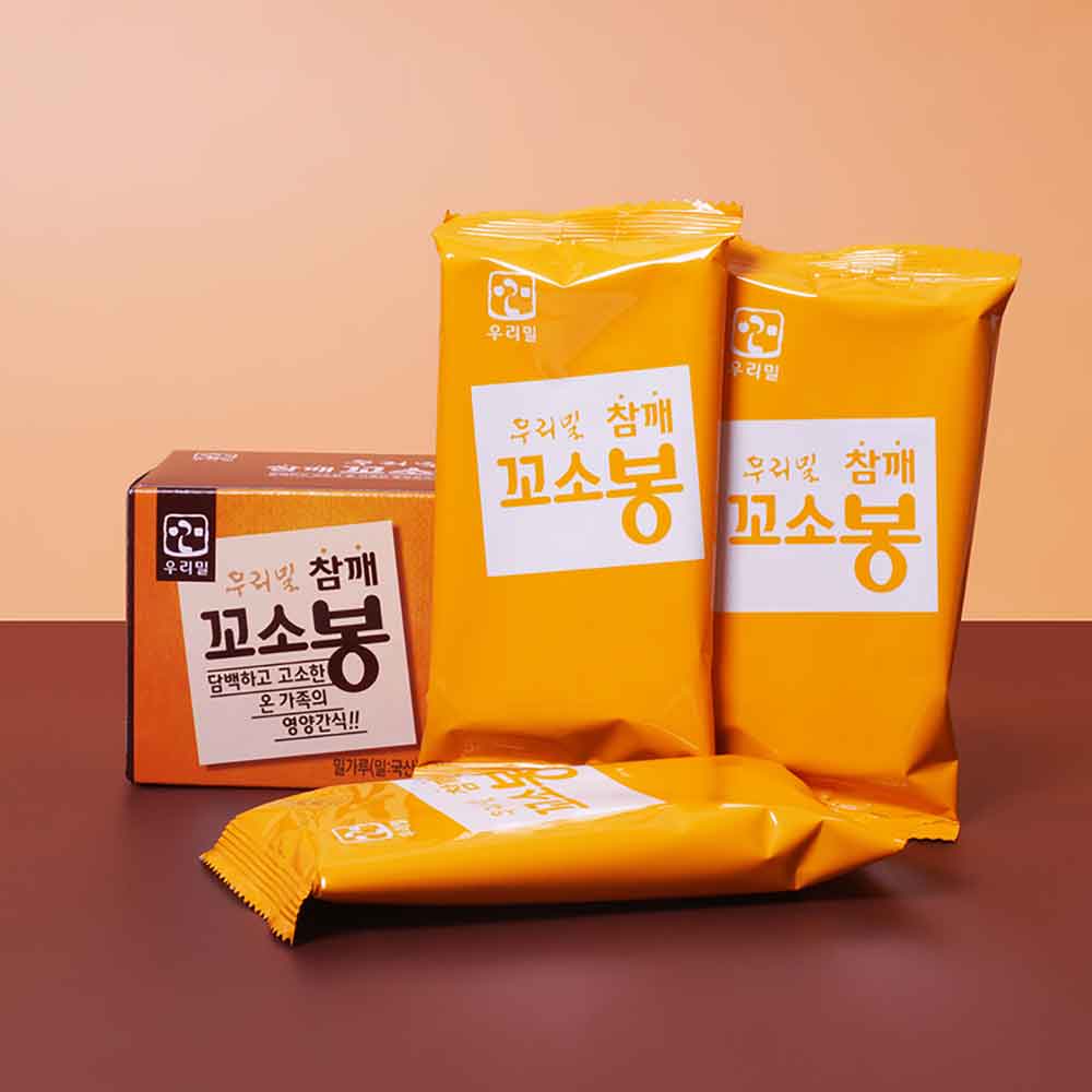 Sesame stick cookies in orange-yellow sealed packages, with one wrapped stick