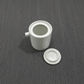 White ceramic candle jar with matching circular saucer and side spout
