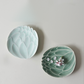 Two lotus dessert plates: sky blue and celadon green with flower garnish