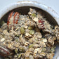 Granola in a speckled bowl with oats, seeds, and dried fruit bits