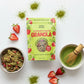 Strawberry Matcha granola bag with strawberries, bowl of granola, and green tea