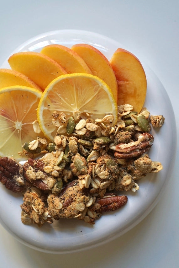 Granola with sliced oranges and oats in a white bowl